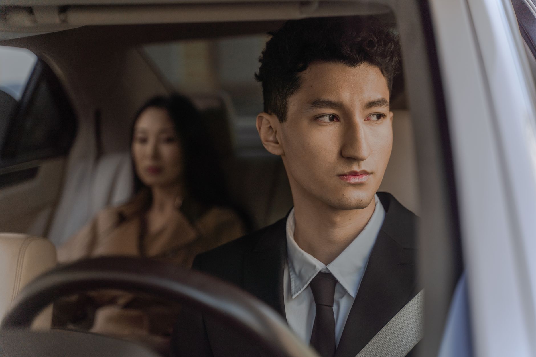 A professionally-dressed TATD driver chauffeuring a passenger